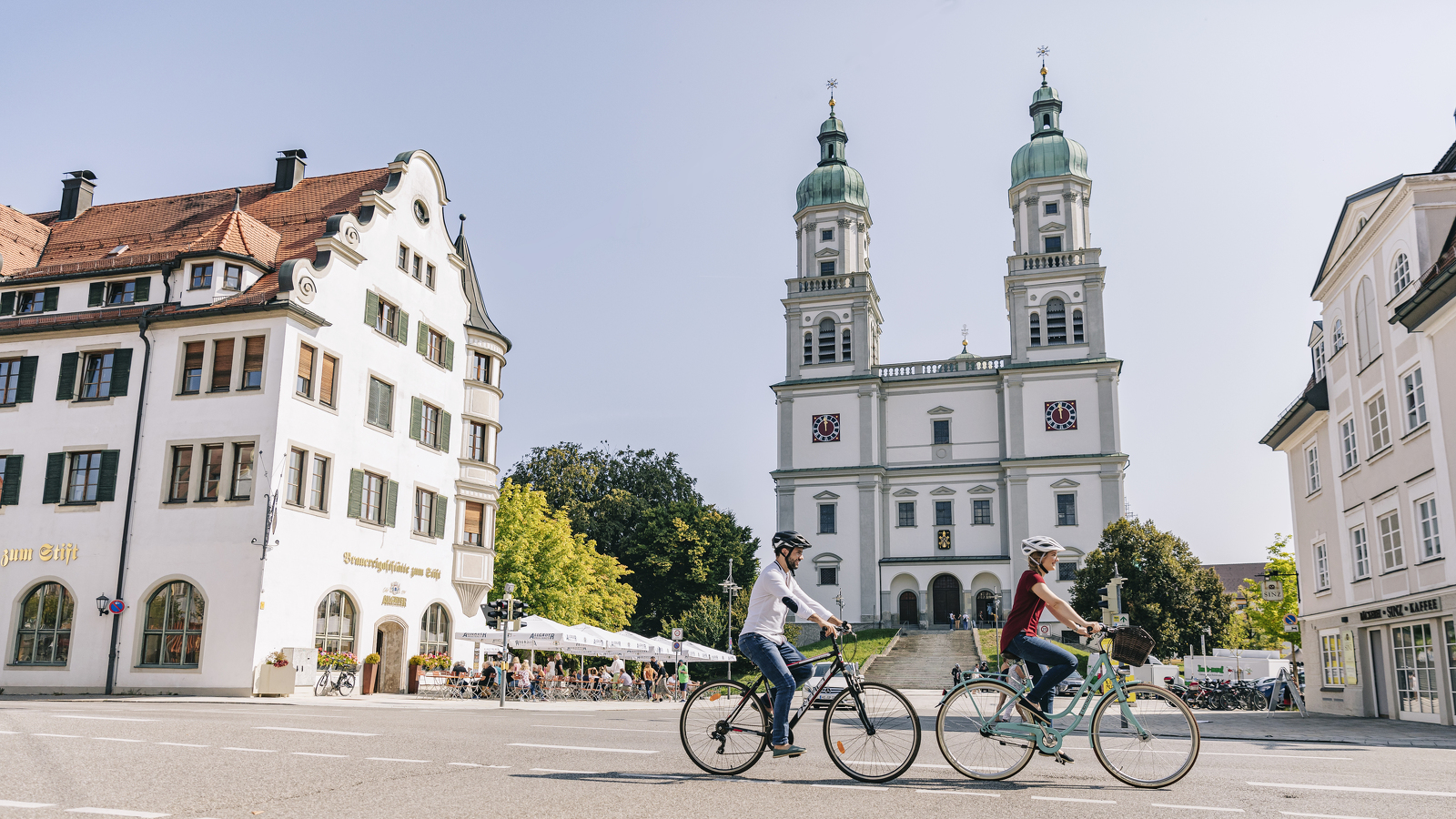 Two cyclists in front of the Stiftsplatz in Kempten