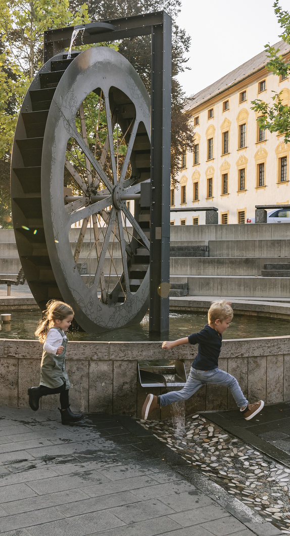 Children playing at the Mühlrad - with a view of the Residence