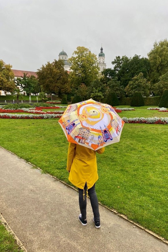 A woman with a Kempten umbrella in the courtyard garden