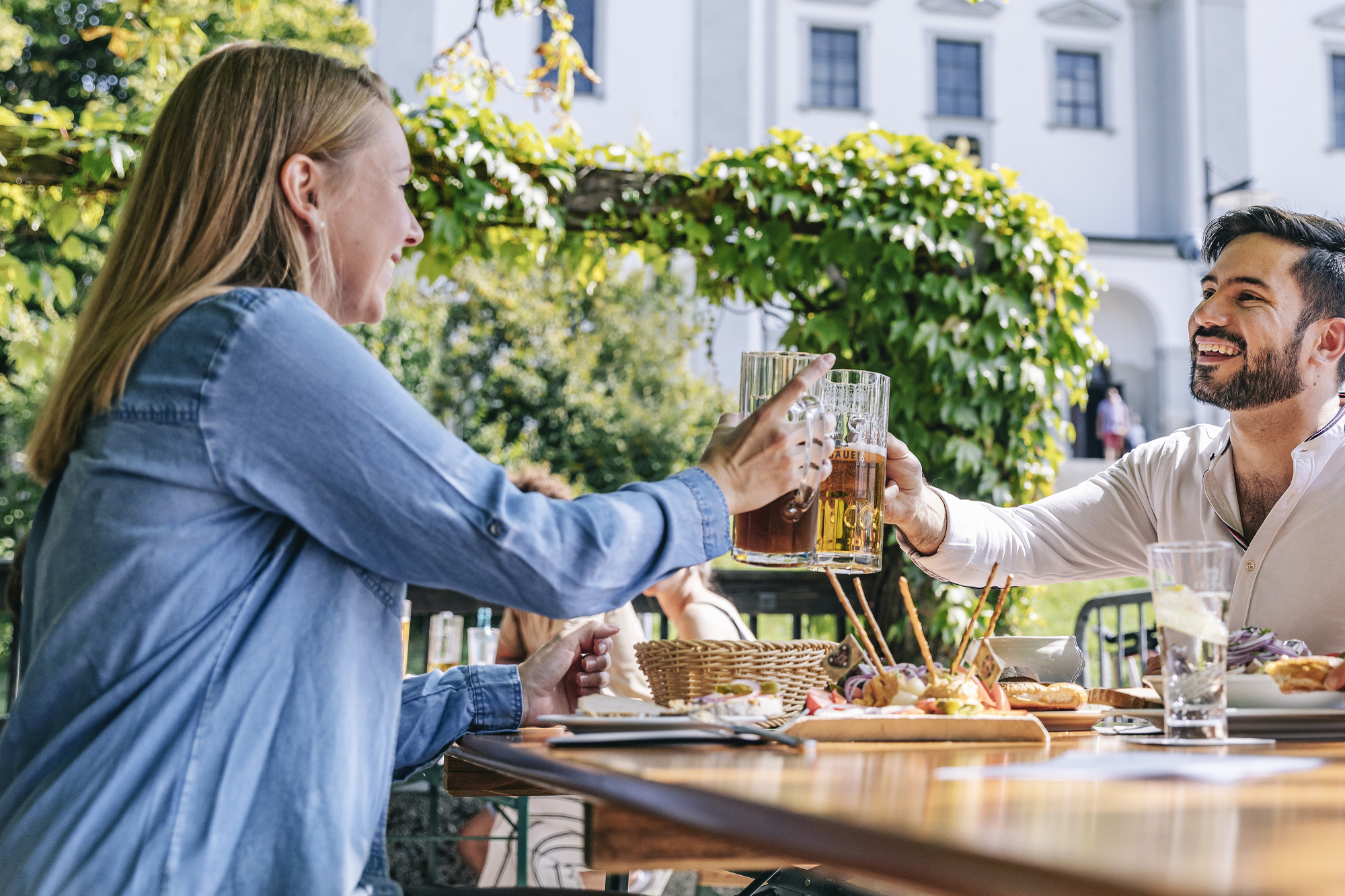 Toast with beer in the beer garden in front of Basilica of St Lorenz