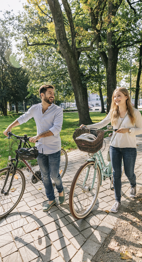 A couple with bicycles in the city park