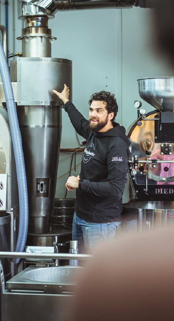 A man in the coffee factory explaining the roasting process