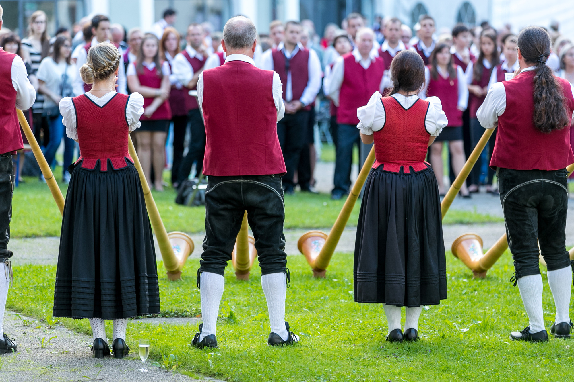 Gruppe von Alphornbläsern musiziert in Tracht