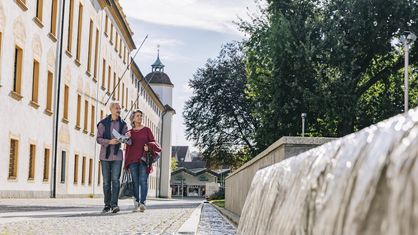 Paar spaziert entlang der Residenz am Residenplatz.