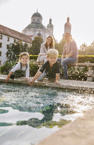 Familie am Mosaik im Hofgarten mit Blick auf die Basilika