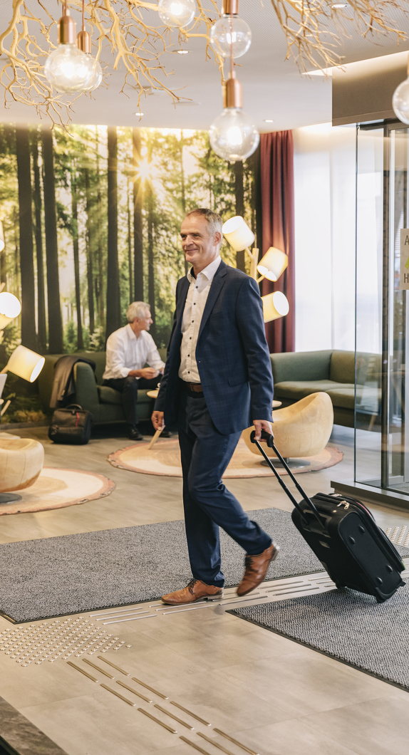 Business-Gast beim Betreten der Hotellobby vom Allgäu ART Hotel