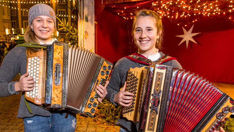 zwei Musikerinnen spielen Ziehharmonika auf dem Kemptener Weihnachtsmarkt