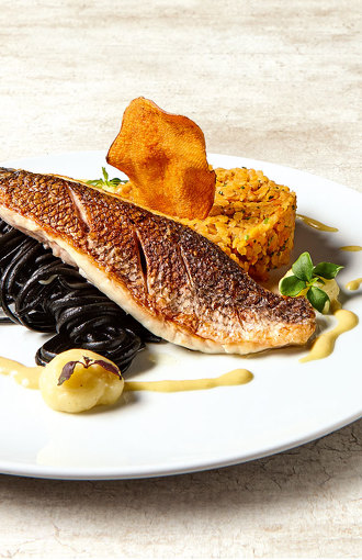 Doradenfilet angerichtet mit Linsenragout und schwarzen Nudeln