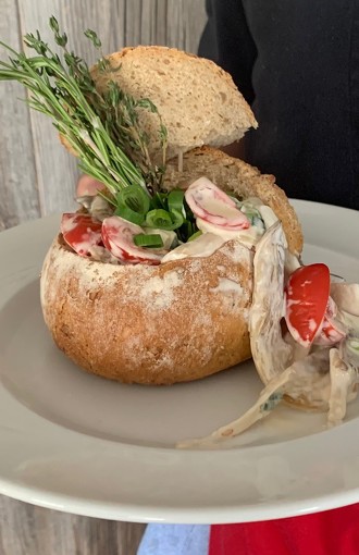 Pilzragout angerichtet in einem kleinen Laib Brot