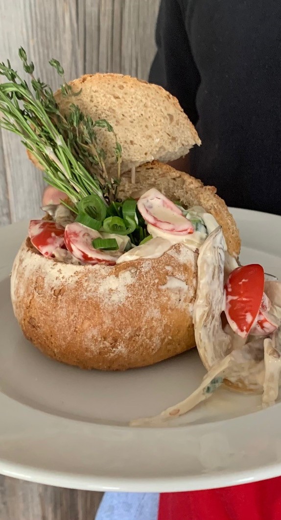 Pilzragout angerichtet in einem kleinen Laib Brot