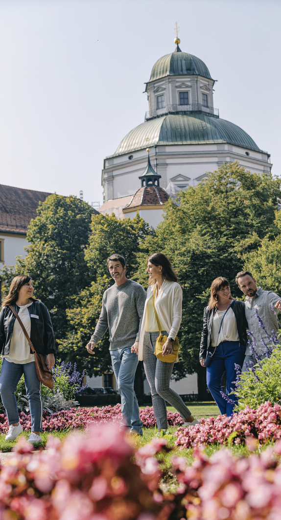 Stadtführerin geht mit Reisegruppe durch den Hofgarten