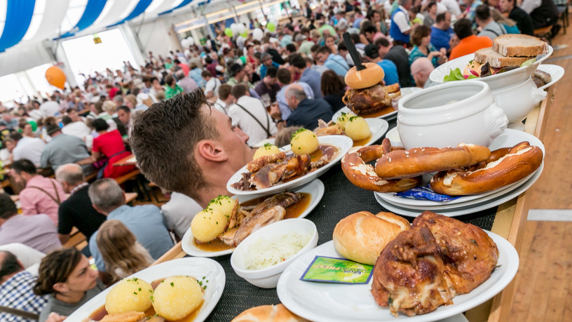 Mann Trägt Essen im gefüllten Festzelt