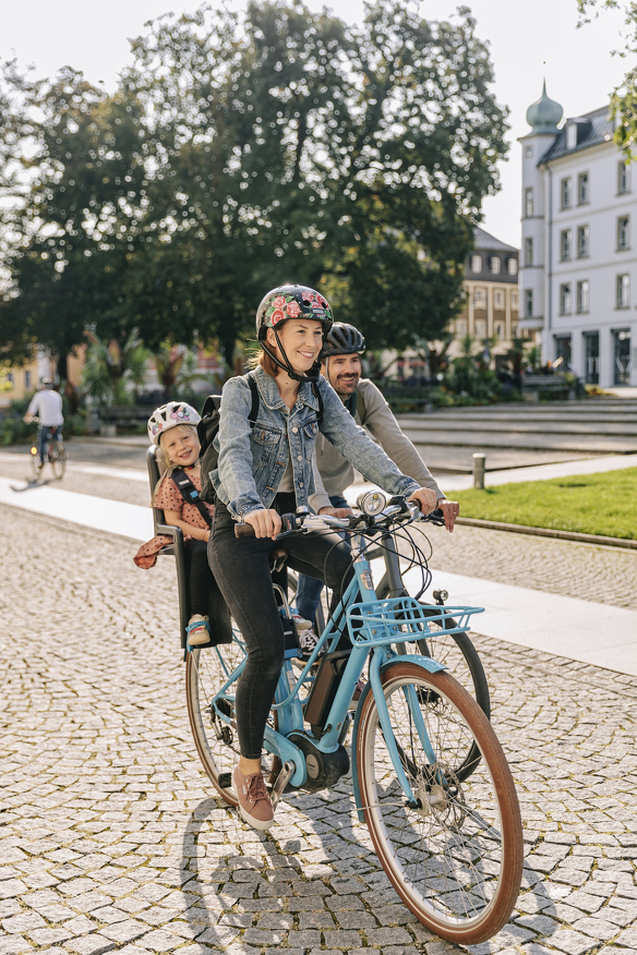 Familie fährt auf Rädern über den Hildegardplatz.