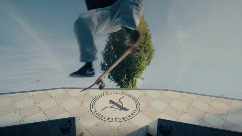 Springender Skater mit Skateboard unter den Füßen