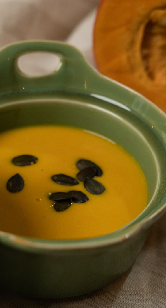 Eine cremige Kürbissuppe mit Sonnenblumenkernen garniert