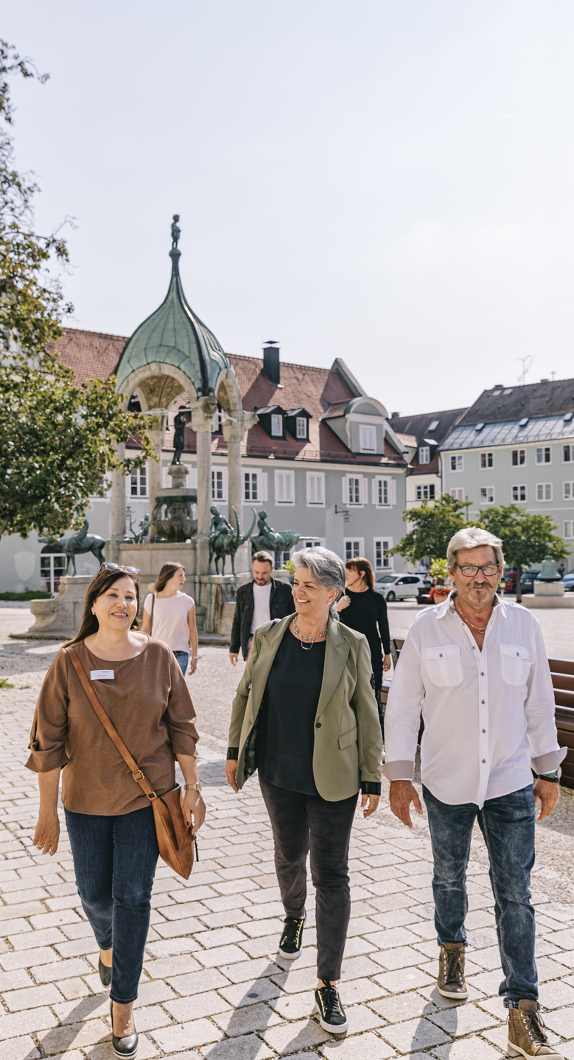 Gästeführerin mit Stadtführungsteilnehmenden auf dem St.-Mang-Platz