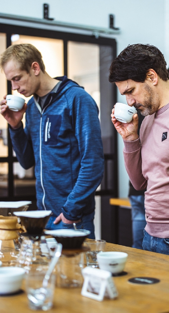Zwei Männer riechen am Kaffee