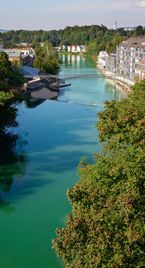 Blick von einer Brücke auf den Iller-Fluss und ein Wasserkraftwerk